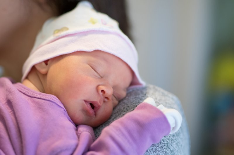 baby asleep on parent’s shoulder 